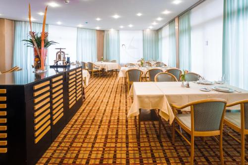 a restaurant with tables and chairs in a room at Hotel Unione in Bellinzona
