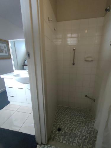 y baño con ducha y lavamanos. en International Hotel Motel en Port Pirie