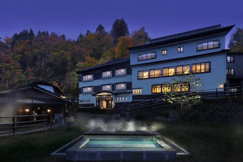 a large house with a pool in front of it at Zao Onsen Omiya Ryokan in Zaō Onsen