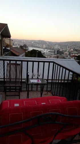 uma varanda com uma mesa e 2 copos de vinho em Histórica y cómoda em Valparaíso