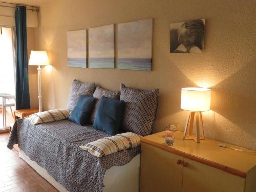 une chambre avec un lit avec des oreillers bleus dans l'établissement T2 Climatisé avec Piscine, Tennis, Garage, Proche Plage – Bormes-les-Mimosas - FR-1-610-34, à Bormes-les-Mimosas