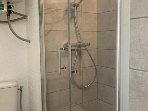 une douche avec une porte vitrée dans une salle de bain dans l'établissement T2 Climatisé avec Piscine, Tennis, Garage, Proche Plage – Bormes-les-Mimosas - FR-1-610-34, à Bormes-les-Mimosas