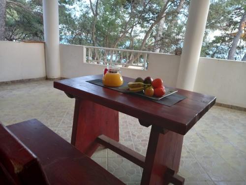 a wooden table with a plate of fruit on it at Apartments by the sea Ivan Dolac, Hvar - 21269 in Jelsa