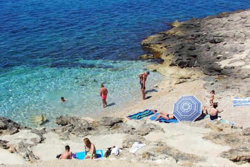 a group of people on a beach near the water at Apartments by the sea Ivan Dolac, Hvar - 21269 in Jelsa