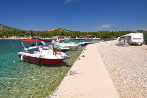 un grupo de barcos están atracados en una playa en Lado Mobile Home Croatia, Camp Oaza Lučica, Drage, en Drage