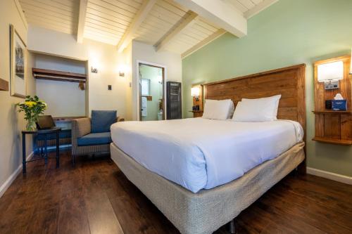 a bedroom with a large white bed and a chair at Emerald Bay Lodge in South Lake Tahoe