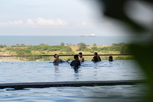 a group of people swimming in the water at Amber Cove Impression City Melaka By Dawn Stay Free Netflix in Melaka