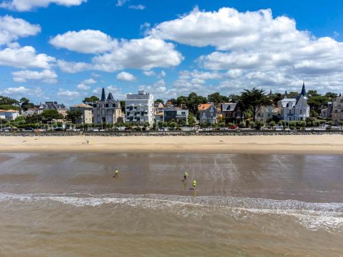 2 personnes se tiennent dans l'eau à la plage dans l'établissement Studio Centre-Ville Royan : Plages et Commerces à Pied, Balcon, Parking Gratuit - FR-1-550-7, à Royan