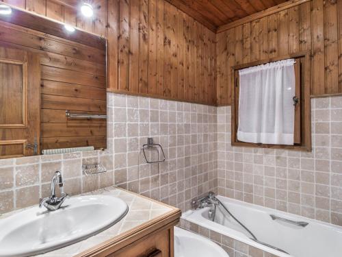 La salle de bains est pourvue d'un lavabo, d'une baignoire et d'un miroir. dans l'établissement Chalet Megève, 5 pièces, 8 personnes - FR-1-453-233, à Megève