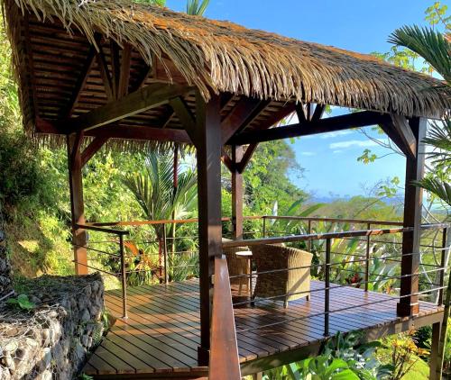 a wooden deck with a thatched roof at Villas by Tekoa in Uvita