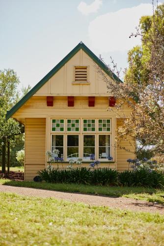 a yellow house with a green roof and windows at Clifton Homestead in Ranelagh