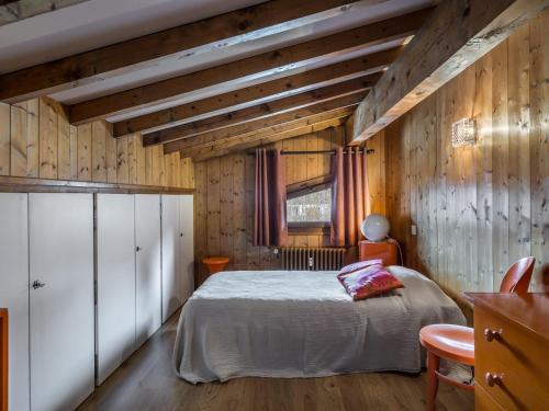 une chambre avec un lit et un mur en bois dans l'établissement Duplex cosy 4 chambres à Rochebrune, proche centre avec balcon, parking et Wi-Fi - FR-1-453-245, à Megève