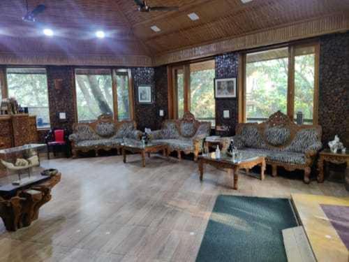 ein großes Wohnzimmer mit Sofas, Tischen und Fenstern in der Unterkunft Flagship Sitar Guest House in Rudrapur