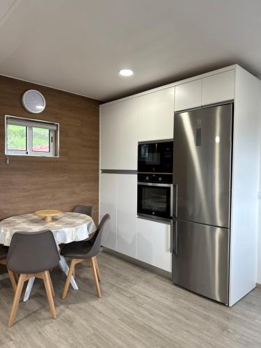 a kitchen with a table and a stainless steel refrigerator at Paradise Apartments III in Santa Cruz das Flores