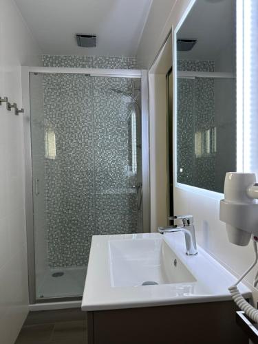 Paradise Apartments III في سانتا كروز داس فلوريس: حمام مع حوض ودش زجاجي