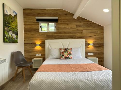 a bedroom with a white bed and wooden walls at Paradise Apartments III in Santa Cruz das Flores