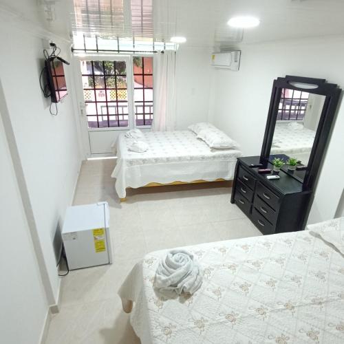 a bedroom with two beds and a mirror at Hotel Campestre Dorado SAI in San Andrés