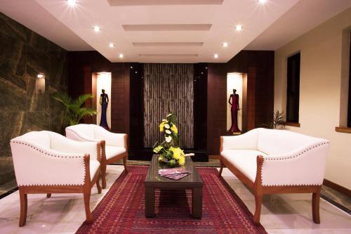 a lobby with white chairs and a table at Bidwood Suite Hotel in Nairobi