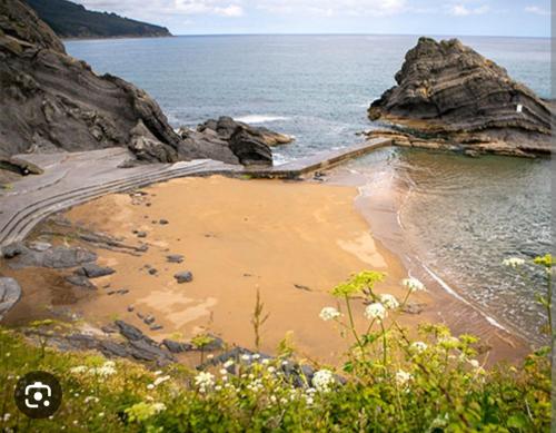 a view of a beach with rocks and the ocean at Gure Torrontero in Bermeo
