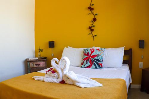 two towel swans sitting on top of a bed at MarTito Forno Pousada - Armação dos Buzios in Búzios