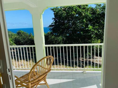 um alpendre com uma cadeira e vista para o oceano em Villa Salako, Terre-de-Bas - Bas de Villa em Terre-de-Bas