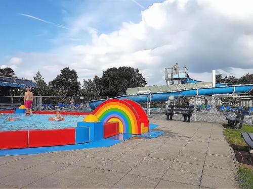 a pool with a rainbow and a water slide at Holiday Home Zeeland near Westerschelde in Baarland