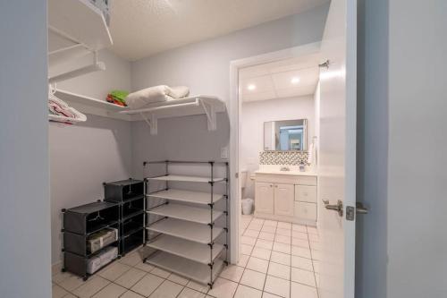 a bathroom with a white tiled floor and a white closet at Sunny Isles vacation condo. in Miami Beach