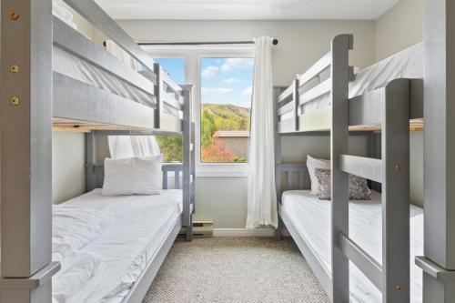 two bunk beds in a room with a window at Mountain View Wintergreen Home 84140 in Blue Mountains