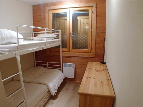 Cette petite chambre comprend des lits superposés et une fenêtre. dans l'établissement Appartement lumineux avec terrasse, parking et lave-vaisselle, à 2 pas du centre de Samoëns - FR-1-629-48, à Samoëns