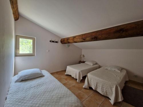 a bedroom with two beds and a window at Semi-detached house, Lacoste in Lacoste