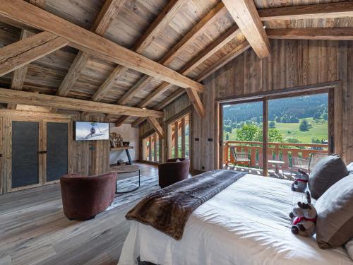 a bedroom with a large bed and a large window at Chalet Demi-Quartier, 7 pièces, 12 personnes - FR-1-569-19 in Demi-Quartier