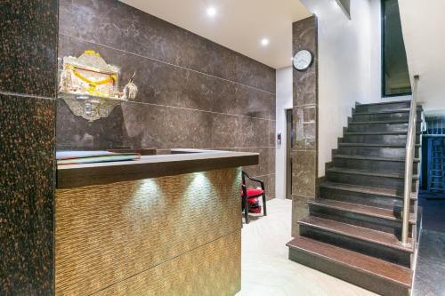 a staircase leading to a lobby with a counter and stairs at Hotel Prince Residency in Thane
