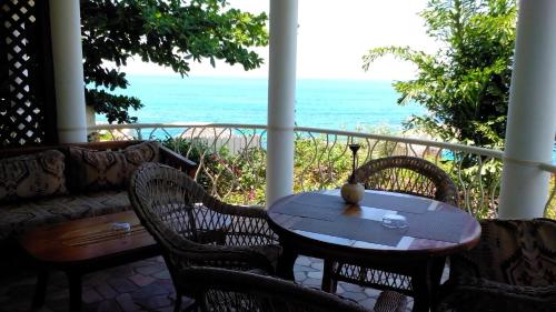 a porch with a table and chairs and the ocean at Catcha Falling Star in Negril