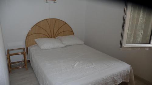 a bed with a wooden headboard in a room at PLEINE VUE MER PISCINE duplex parking privé fibre wifi plage 6 minutes a pied st pierre la mer in Fleury