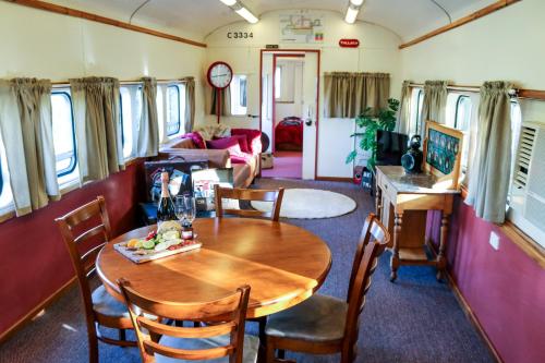 a dining room with a table and chairs in a train at Carriageway Retreat - Unique Red Rattler Carriages and Units in Brookfield
