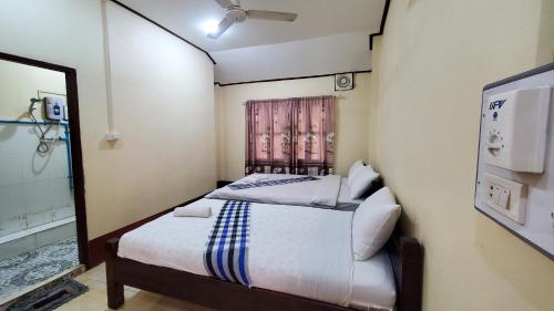 um pequeno quarto com uma cama e uma janela em Pakbeng Guesthouse em Pakbeng