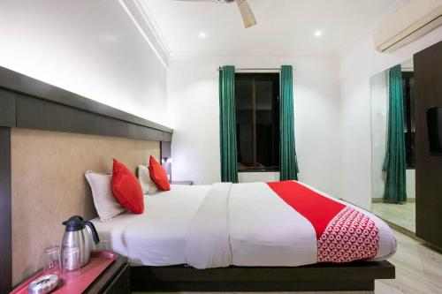 a bedroom with a large bed with red pillows at Hotel Prince Residency in Thane