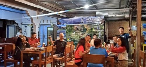 un gruppo di persone sedute ai tavoli di un ristorante di Anak Rinjani Guest House a Senaru