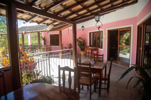 a patio with a table and chairs on a balcony at Pousada Casa Rosa in Alto Paraíso de Goiás