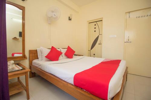 a bedroom with a large bed with red and white sheets at Capital O Hotel Red Cherry in Gangtok