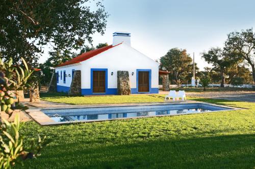 a house with a swimming pool in the yard at Monte Azul - Casas de Campo do Junqueirinho in Bicos