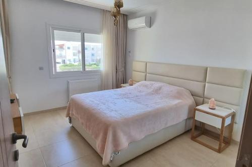 a bedroom with a large bed and a window at Fantastique, luxerieux, agreabel appartement in Monastir