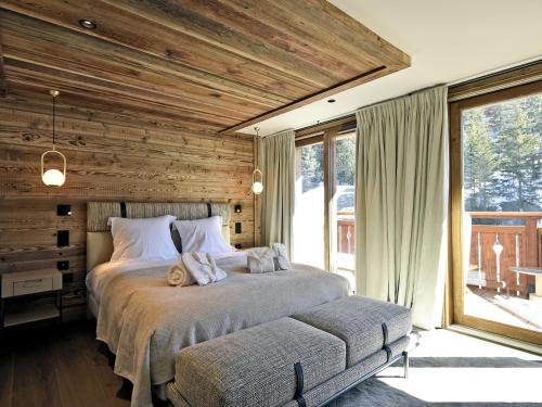 a bedroom with two beds and a large window at Penthouse Luxueux à Méribel avec SPA et Services Inclus - FR-1-613-32 in Méribel