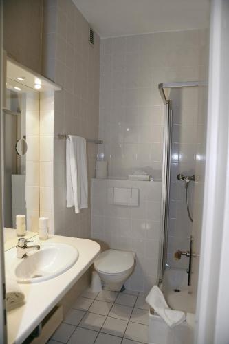 a bathroom with a sink and a toilet and a shower at Landhotel Klingerhof in Hösbach