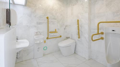a white bathroom with a toilet and a sink at Toyoko Inn Imba Nihon-idai Ekimae in Inzai