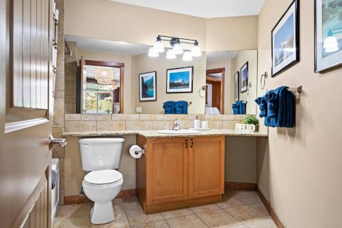 a bathroom with a toilet and a sink and a mirror at ⭐️ Luxury Mountain View Studio in Canmore ⭐️ in Canmore