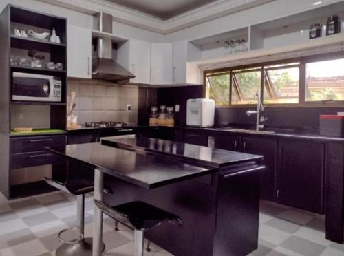 uma cozinha com um balcão preto numa cozinha em Leotel hospedagem em Serra