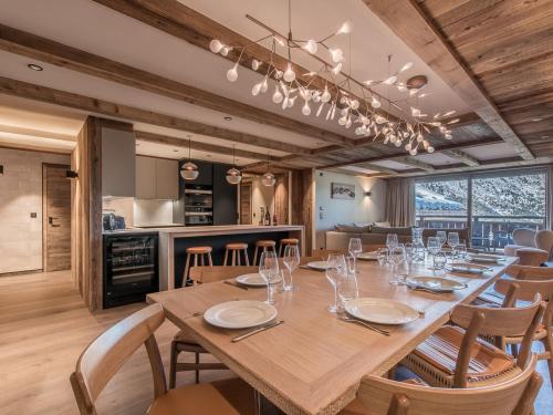 une salle à manger avec une grande table et des chaises en bois dans l'établissement Appartement Luxueux avec Spa, Parking & Wi-Fi à Méribel - FR-1-613-60, à Les Allues