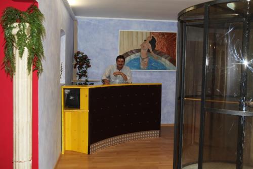 un hombre parado en un mostrador en una habitación con una pintura en Villa Monti Lepini, en Segni