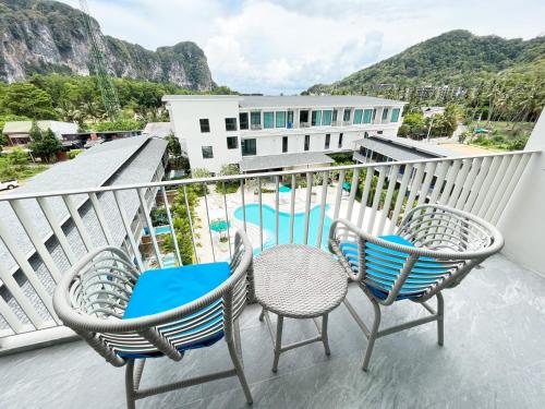 a balcony with three chairs and a swimming pool at Infinity Aonang Krabi in Ao Nang Beach